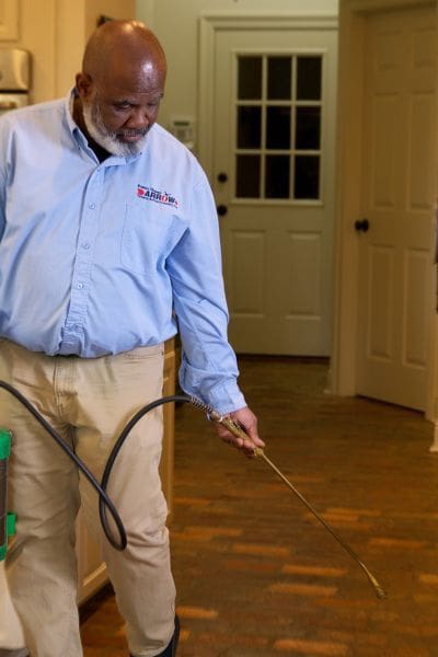 pest control technician spraying chemical